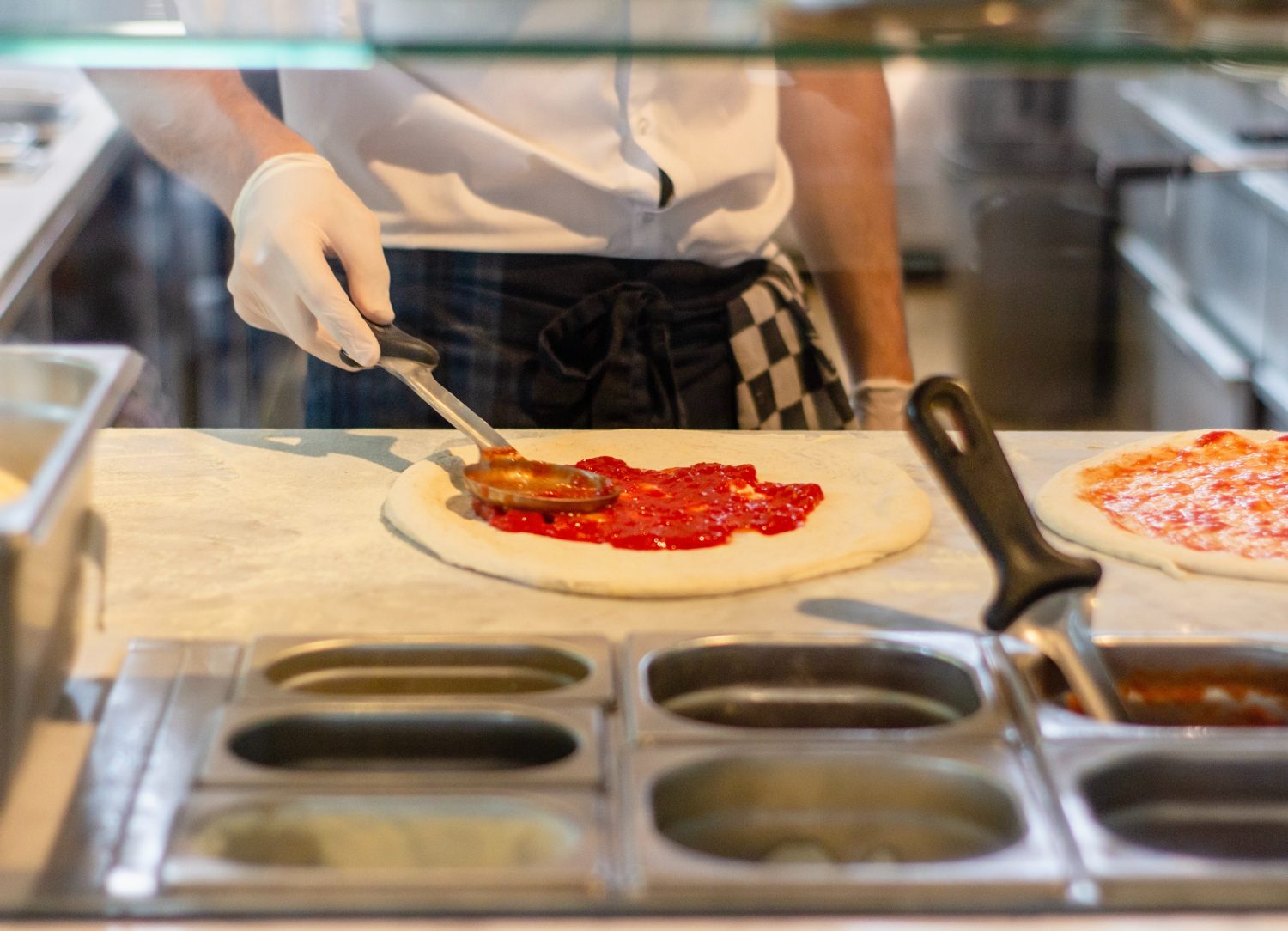 spreading-tomato-sauce-on-pizza
