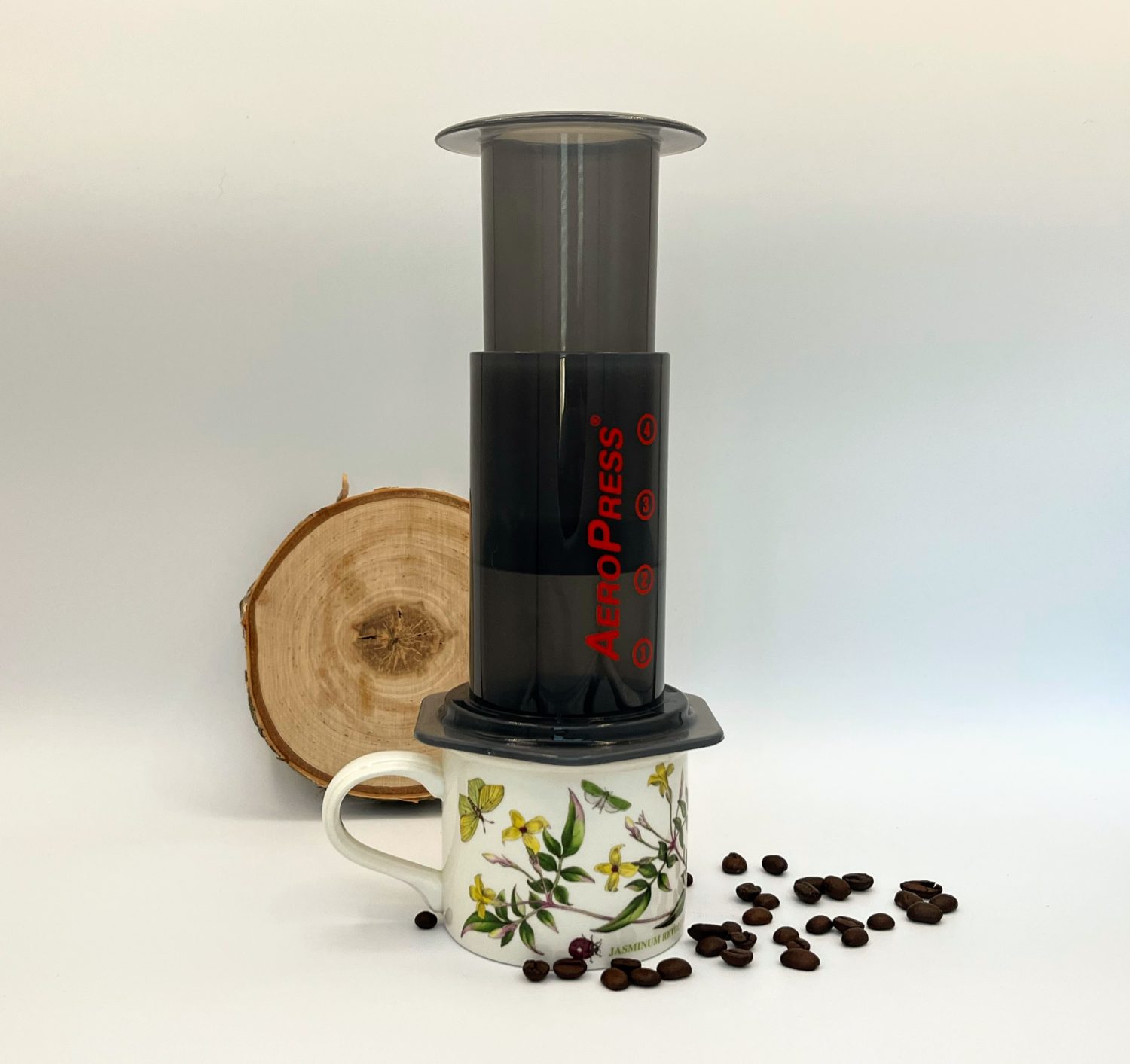 aeropress-sitting-on-mug-with-scattered-coffee-beans