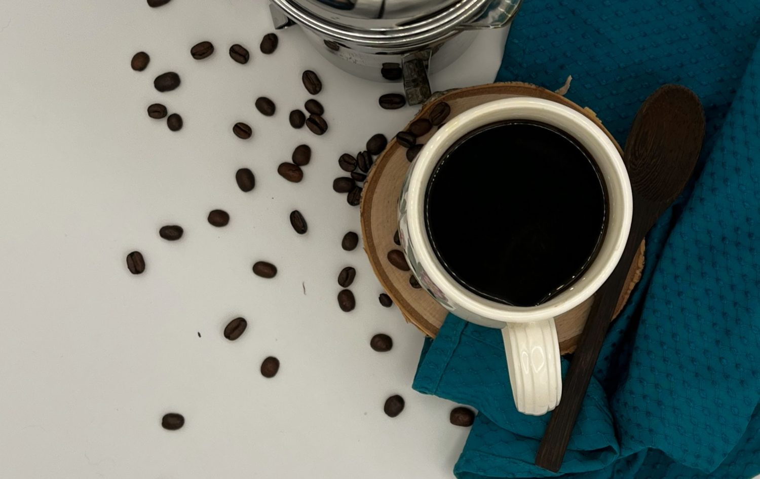 cup-of-french-press-coffee-surrounded-by-scattered-coffee-beans